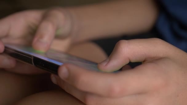 Child hand touching mobile phone screen while playing a game. close up. Childhood and modern technology concept. — Stock Video