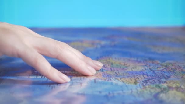 Επιλογή χώρας για ταξίδια. Πού να πάει στις διακοπές. Το χέρι στο φόντο του παγκόσμιου χάρτη — Αρχείο Βίντεο