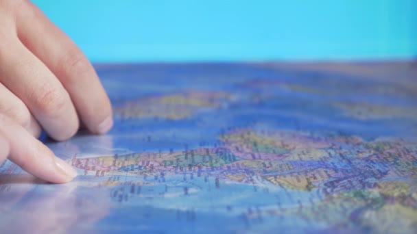 Επιλογή χώρας για ταξίδια. Πού να πάει στις διακοπές. Το χέρι στο φόντο του παγκόσμιου χάρτη — Αρχείο Βίντεο