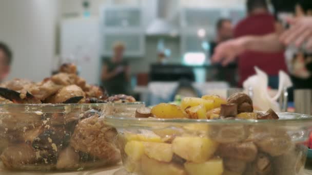 Conceito de uma festa em casa. refeições com alimentos na mesa de férias em foco, as pessoas em segundo plano são turvas . — Vídeo de Stock