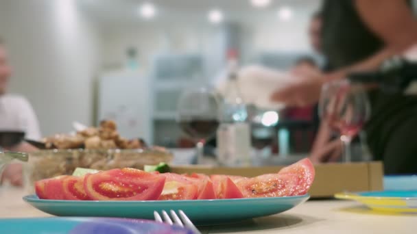 Konzept eines Festes zu Hause. Mahlzeiten mit Essen auf dem Festtagstisch im Fokus, Menschen im Hintergrund verschwimmen. — Stockvideo