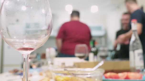 Concepto de una fiesta en casa. comidas con comida en la mesa de vacaciones en foco, las personas en el fondo están borrosas . — Vídeos de Stock
