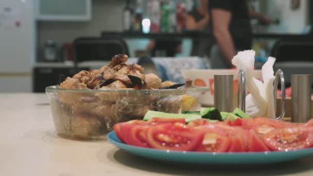 Concepto de una fiesta en casa. comidas con comida en la mesa de vacaciones en foco, las personas en el fondo están borrosas . — Vídeo de stock