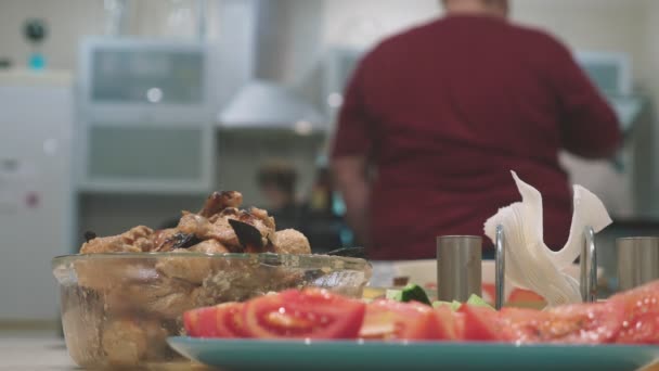 Concepto de una fiesta en casa. comidas con comida en la mesa de vacaciones en foco, las personas en el fondo están borrosas . — Vídeos de Stock