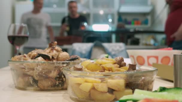 Concepto de una fiesta en casa. comidas con comida en la mesa de vacaciones en foco, las personas en el fondo están borrosas . — Vídeos de Stock