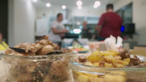 Konzept eines Festes zu Hause. Mahlzeiten mit Essen auf dem Festtagstisch im Fokus, Menschen im Hintergrund verschwimmen. — Stockvideo