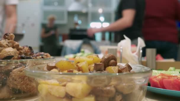 Concepto de una fiesta en casa. comidas con comida en la mesa de vacaciones en foco, las personas en el fondo están borrosas . — Vídeo de stock