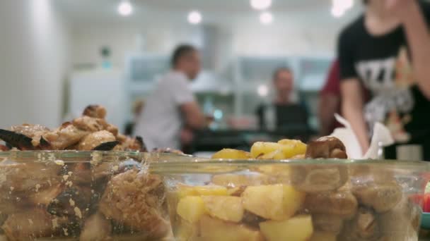 Concept van een feest thuis. maaltijden met eten op de tafel van de vakantie in focus, mensen op de achtergrond zijn wazig. — Stockvideo