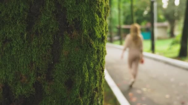 Mujer rubia joven camina a través del parque de otoño, ella recoge hojas de arce caído colorido — Vídeos de Stock