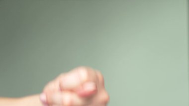 Güzel el zarif manikür ile bir incir, mavi arka plan belirtisi gösterir. beden dili