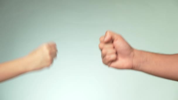 Dwie ręce na niebieskim tle. Młody mężczyzna i kobieta są gry kamień papier nożyce — Wideo stockowe