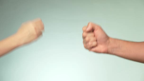 Две руки на синем фоне. Молодой человек и женщина играют в камень ножницы бумаги — стоковое видео