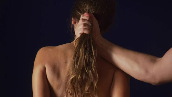 Mão masculina segurando uma mulher pelo cabelo . — Fotografia de Stock