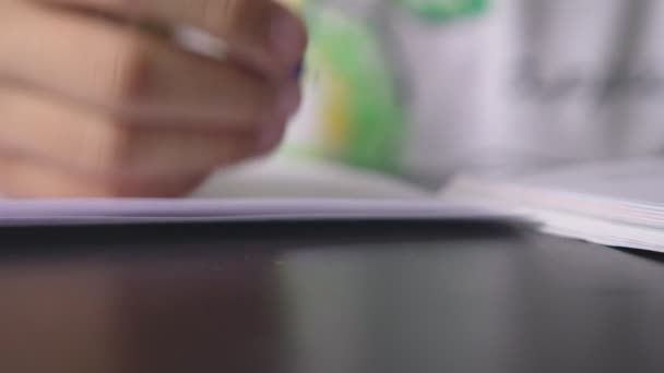 Дівчина-підліток робить домашнє завдання для школи в її кімнаті, на столі — стокове відео