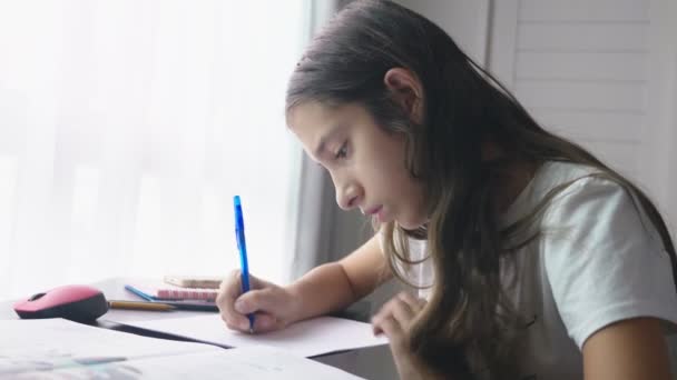 Teenager-Mädchen macht Hausaufgaben für die Schule in ihrem Zimmer, auf dem Schreibtisch — Stockvideo