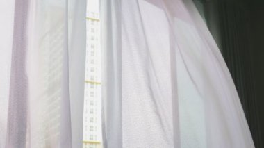 Saydam pencere perde, yavaşça rüzgar tarafından taşındı. Pencerenin dışında yeşil ağaçların yaprakları görebilirsiniz