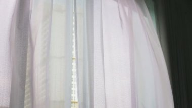 Saydam pencere perde, yavaşça rüzgar tarafından taşındı. Pencerenin dışında yeşil ağaçların yaprakları görebilirsiniz