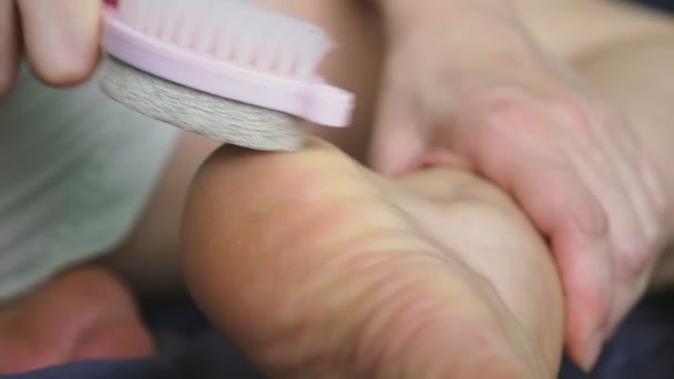 Care for dry skin on feet and heels using pedicure pumice tools and a brush. — Stock Video