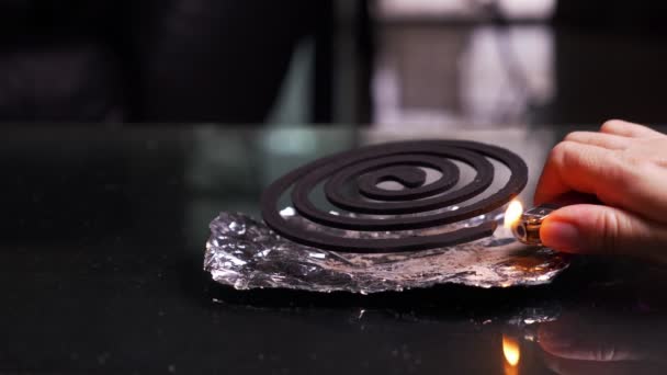 Close-up, hands set fire to black spiral insect repellent mosquito, coil incense smoking. — Stock Video