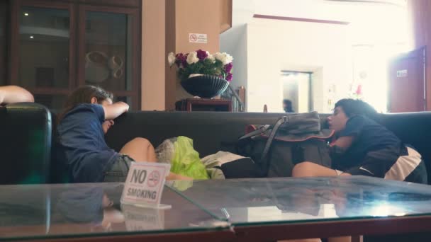 Rodina turisty, hosty dorazil na letovisko a čekání na pokoj. děti usnul na pohovce v hale — Stock video