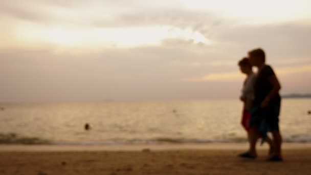 剪影, 老年妇女走在海边, 在海景的背景下, 在海上的红色戏剧性的日落, 太阳把大海描绘成红色. — 图库视频影像