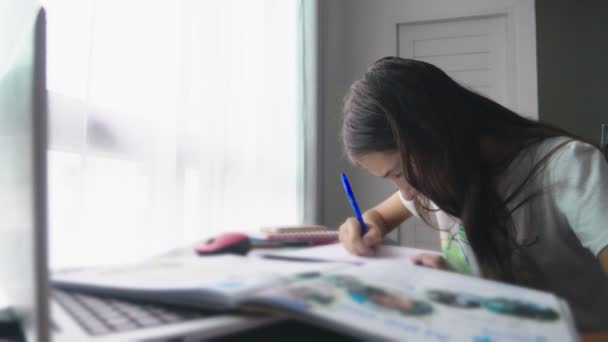 Teenager-Mädchen macht Hausaufgaben für die Schule in ihrem Zimmer, auf dem Schreibtisch — Stockvideo