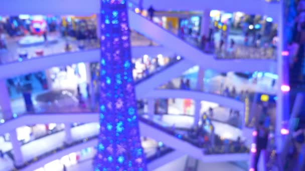 El concepto de compras navideñas. Blur hall en un enorme centro comercial moderno con un montón de escaleras mecánicas y un árbol de Navidad — Vídeo de stock