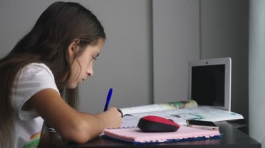Genç kız masanın üstünde onun odasına okul için ödev