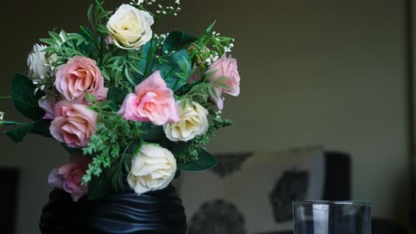 Närbild, en bukett rosor och ett glas rent vatten på bordet — Stockvideo
