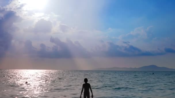 Los rayos del sol brillan a través de hermosas nubes blancas sobre el mar . — Vídeos de Stock