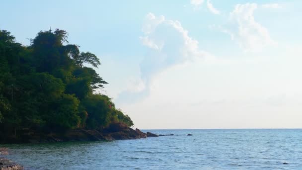 Meereslandschaft, Berg mit grünen Bäumen vor blauem Meer, Himmel mit weißen Wolken und Meer — Stockvideo