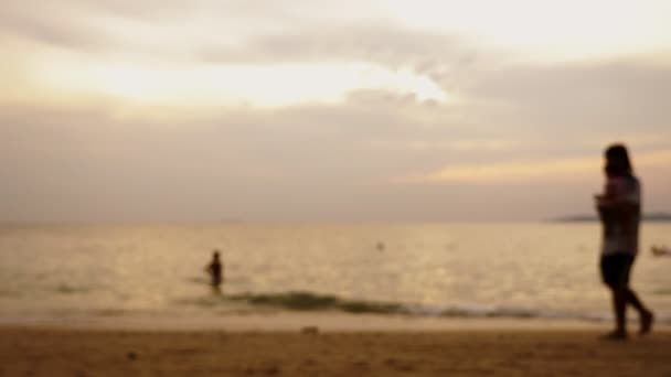 실루엣, 바다 풍경의 배경으로 해변을 따라 산책 하는 노인 여자 태양이 바다에 붉은 극적인 석양 페인트 바다 레드. — 비디오