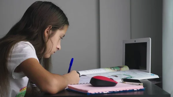 Дівчина-підліток робить домашнє завдання для школи в її кімнаті, на столі — стокове фото