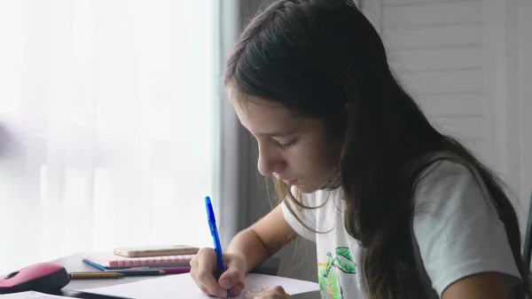 Tizenéves lány csinál házi feladatot a szobájában az íróasztalon iskola — Stock Fotó