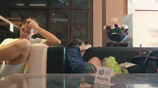 Família Turistas, os hóspedes chegaram ao resort e à espera do quarto. as crianças adormeceram no sofá no lobby — Fotografia de Stock