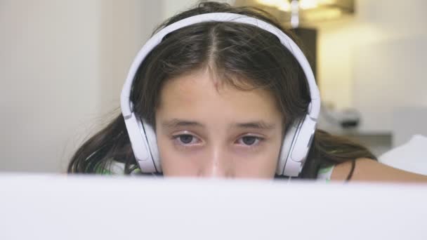Chica adolescente en los auriculares en shock de lo que está sucediendo en la pantalla de su ordenador portátil, porque ella estaba sola. concepto de seguridad de internet para niños — Vídeos de Stock