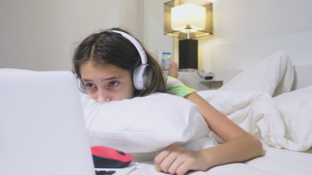 Girl teenager in headphones in shock of what is happening on the screen of her laptop, because she was alone. internet safety concept for kids — Stock Video