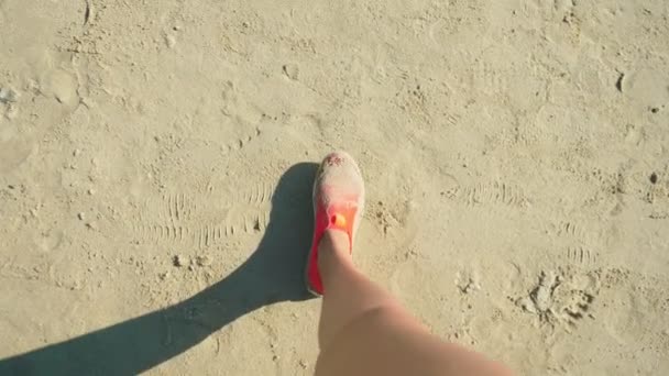 Крупним планом жіночі ноги в червоному взутті для плавання прогулянки на білому піщаному пляжі — стокове відео