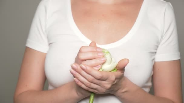 Weiße Lotusblume in den Händen einer jungen Frau an der Brust. — Stockvideo