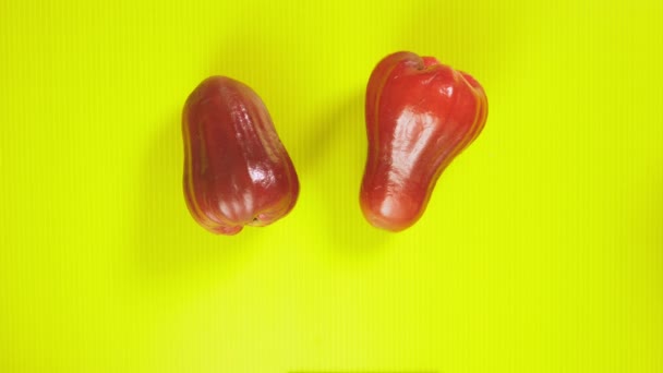 Tropisch fruit op een helder gele achtergrond. ramboetan en rose apple. Minimale fruit concept. — Stockvideo