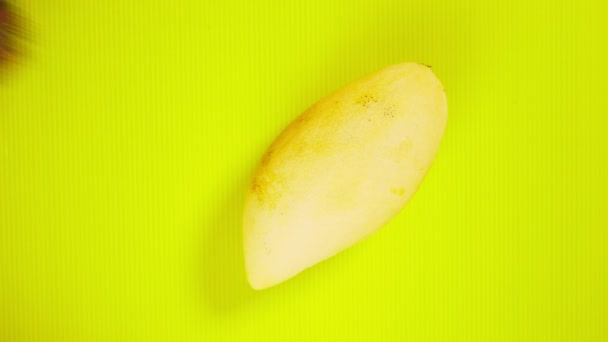 Tropical fruit on a bright yellow background. rambutans and yellow mangoes. Minimal fruit concept. — Stock Video