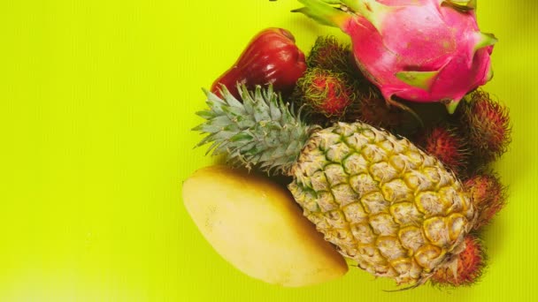 Tropische vruchten op een helder gele achtergrond. Minimale fruit concept. kopie ruimte — Stockvideo