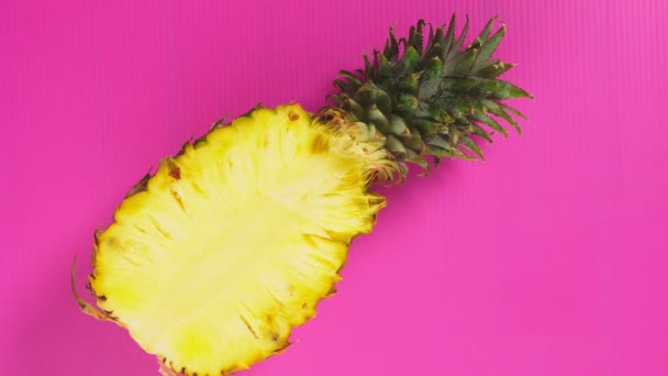Vrouwelijke handen pick-up een ananas met een helder roze achtergrond. Minimale fruit concept. — Stockvideo
