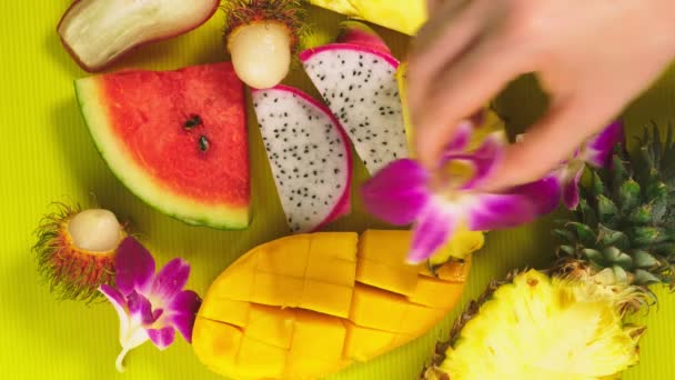 Frutas tropicales sobre un fondo amarillo brillante. Concepto de fruta mínima. espacio de copia — Vídeos de Stock