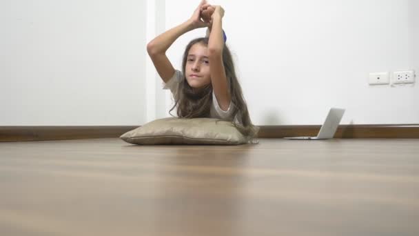 Rugalmasságot és erőt. szép, fiatal lány a tökéletes test stretching izmok otthon, miközben nézte a leckét a nyújtás online hordozható számítógépen — Stock videók