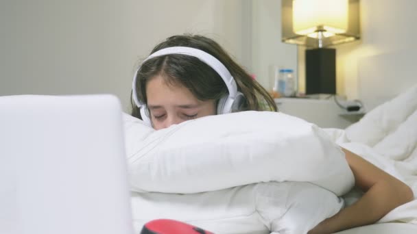 Girl teenager in headphones in shock of what is happening on the screen of her laptop, because she was alone. internet safety concept for kids — Wideo stockowe