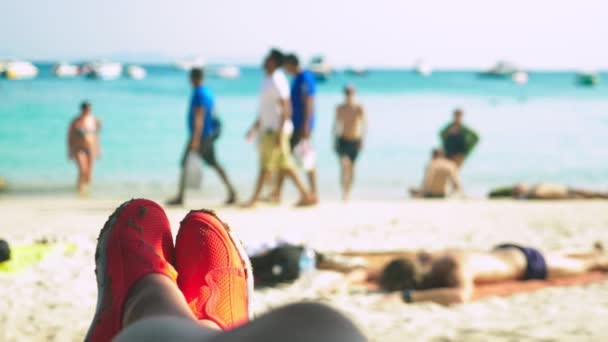 Närbild av kvinnliga ben i röda skor för simning på bakgrunden av azure stranden, oskärpa bakgrund — Stockvideo