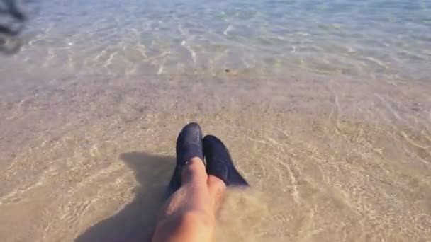 Primo piano di gambe femminili in scarpe nere per nuotare sullo sfondo di acqua di mare trasparente — Video Stock