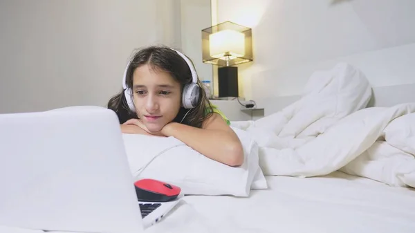 Girl teenager in headphones in shock of what is happening on the screen of her laptop, because she was alone. internet safety concept for kids — Zdjęcie stockowe