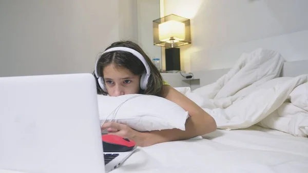 Girl teenager in headphones in shock of what is happening on the screen of her laptop, because she was alone. internet safety concept for kids — Zdjęcie stockowe